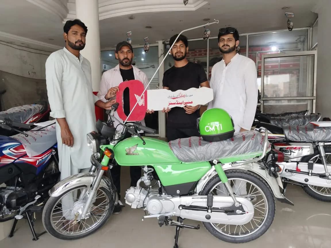 Officials handing over scheme bikes and documents at an authorized dealership