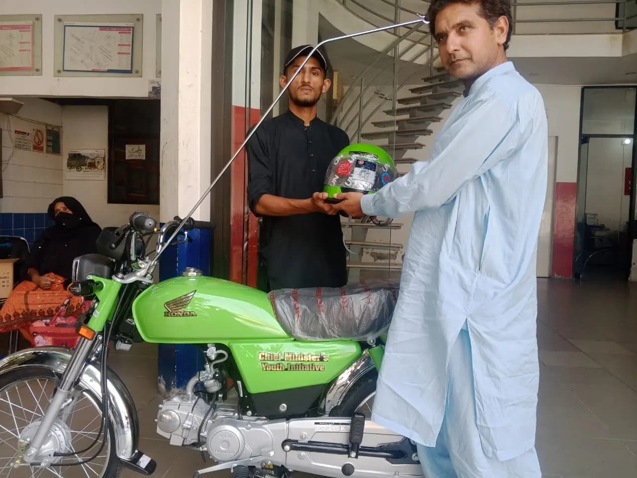 Scheme officials, bank staff and a beneficiary completing bike financing paperwork together