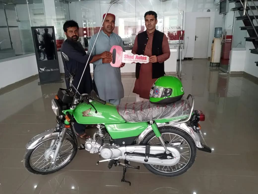 A beneficiary counting out his down payment at a Bank of Punjab counter